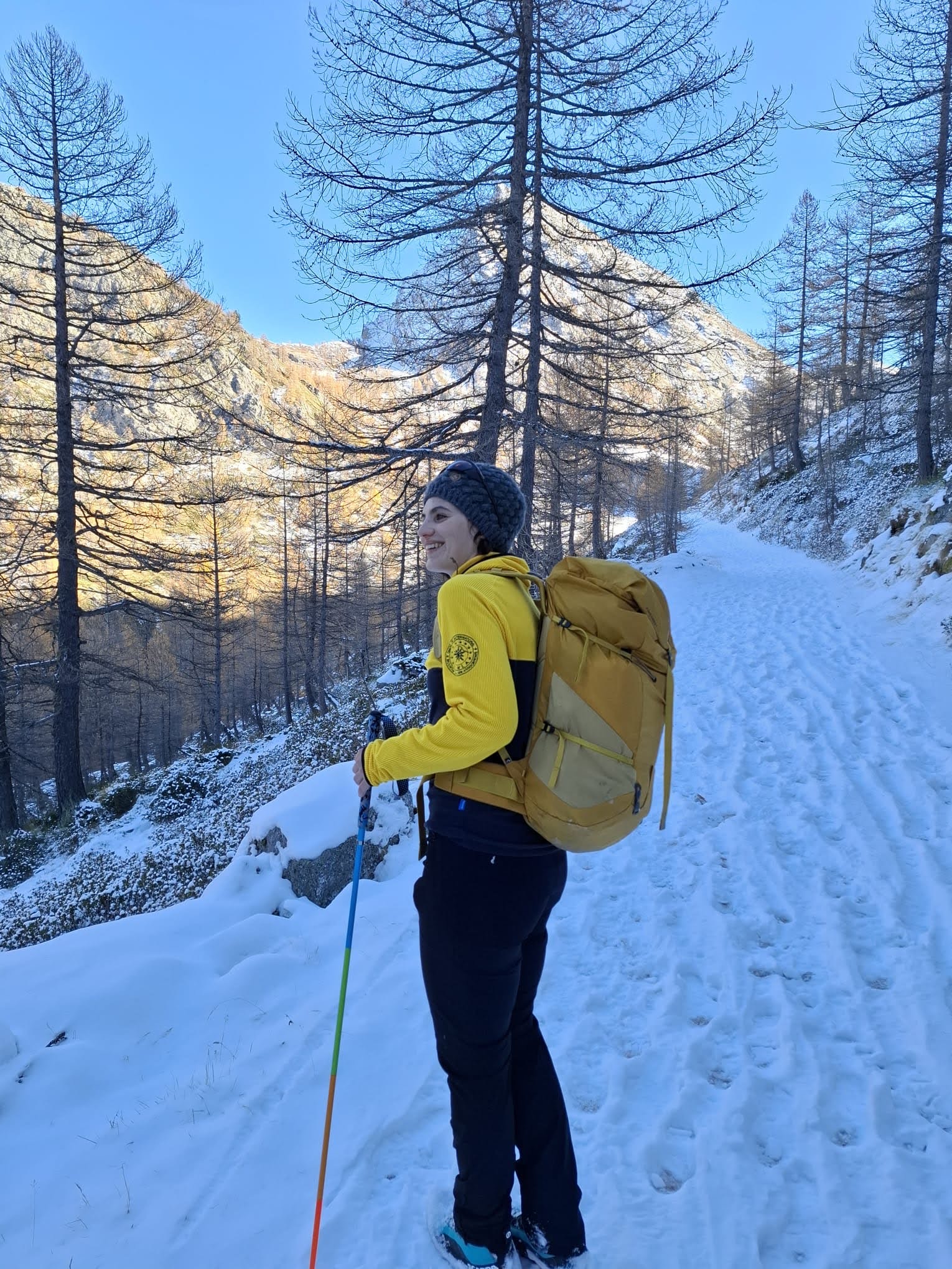 Anna walking with backpack and trekking poles